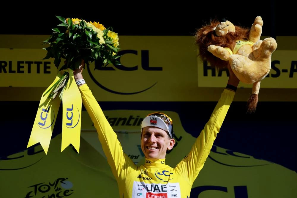 UAE Team Emirates - XRG's Tadej Pogacar celebrates on the podium wearing the yellow jersey after stage 18. (Reuters)