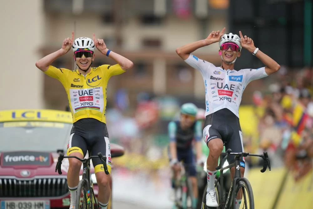 Slovenia's Tadej Pogacar, left, and Mexico's Isaac Del Toro, right, react as they cross the finish line of the twentieth stage of the Tour de France cycling race with start in Le Bourg d'Oisans and finish in Alpe d'huez, France, Saturday, July 25, 2026. (AP)