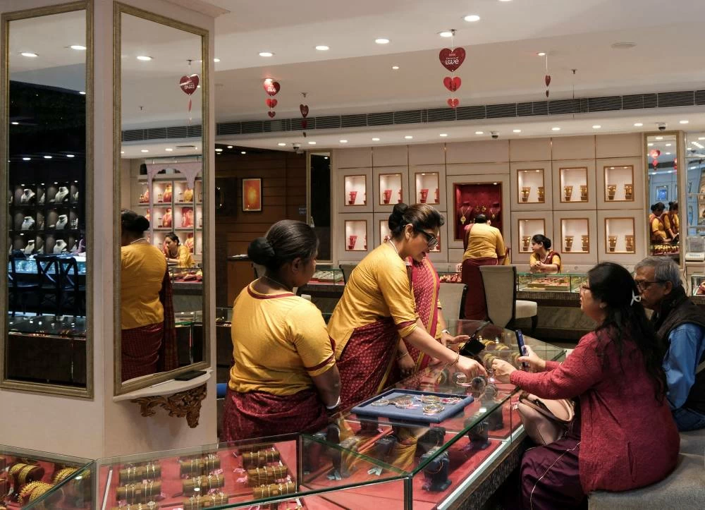 File photo: Saleswomen show gold ornaments and jewellery to customers for purchase inside a Senco Gold & Diamonds jewellery showroom in Kolkata, India. (Reuters)