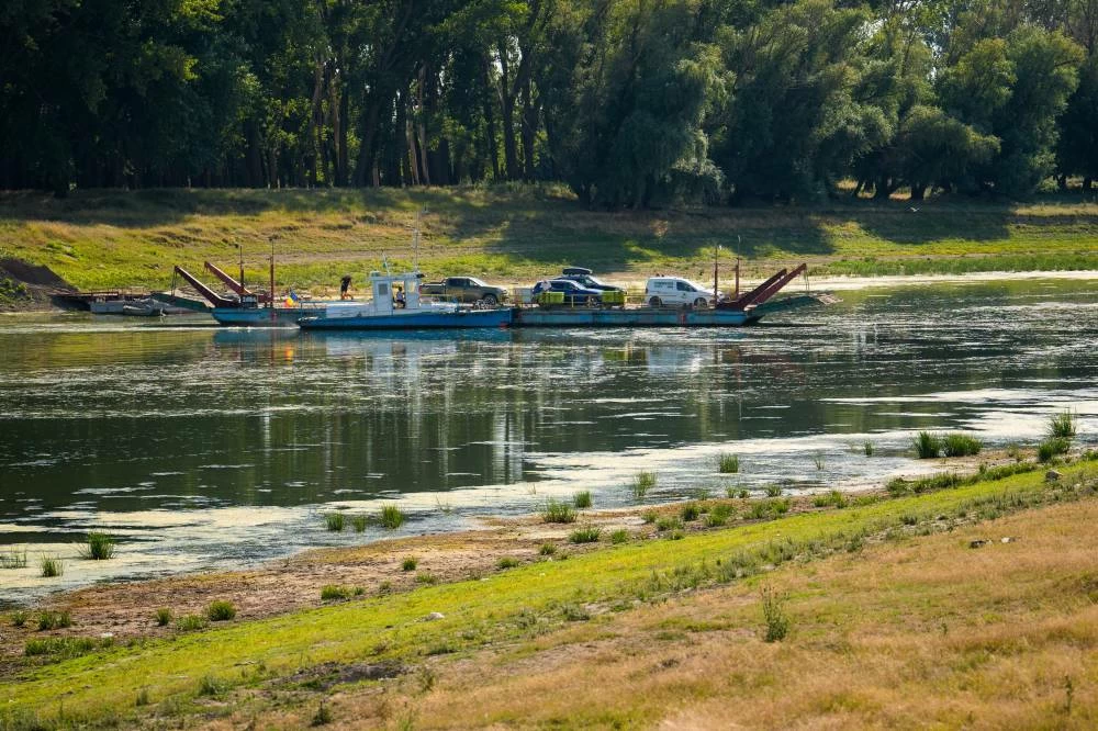 A ferry crosses the Danube River as usually submerged areas are exposed due to extreme low levels of the water following an extended period of drought in Roseti, Romania, Wednesday, July 29, 2026. (AP)