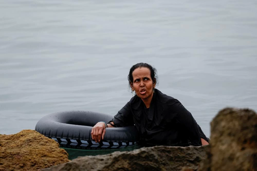 A migrant holds an inflatable ring while in the water, amid mass crossings of migrants on foot and by sea from Morocco into Spanish territory in Ceuta, Spain, July 31, 2026. (Reuters)