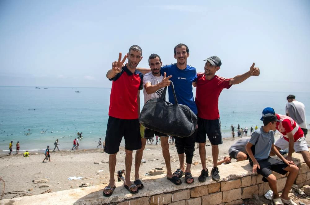 People pose for a photo as they attempt to cross from the Moroccan northern town of Fnideq to the Spanish enclave of Ceuta, Friday, July 31, 2026. (AP)