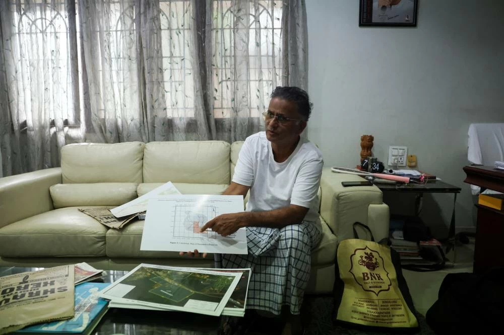 Bolisetty Satyanarayana,an environmentalist, shows a map of the catchment area of the Mudasarlova Reservoir at his residence in Visakhapatnam, Andhra Pradesh. (Reuters)