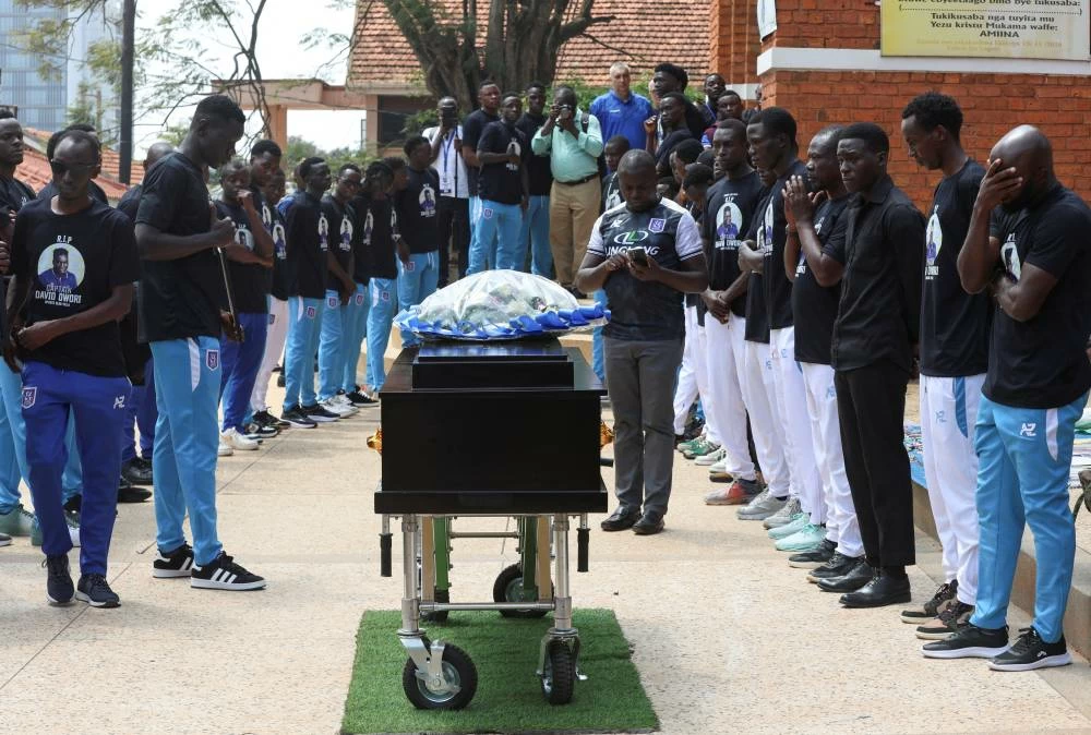 Ugandan soccer players pay homage around the coffin before attending the requiem mass of the late David Owori, 28, Uganda international soccer player and captain of SC Villa, who was critically injured by unidentified assailants and was later pronounced dead, at the St. Peter's Catholic Church Nsambya in Kampala, Uganda August 6, 2026. Picture credit: Reuters