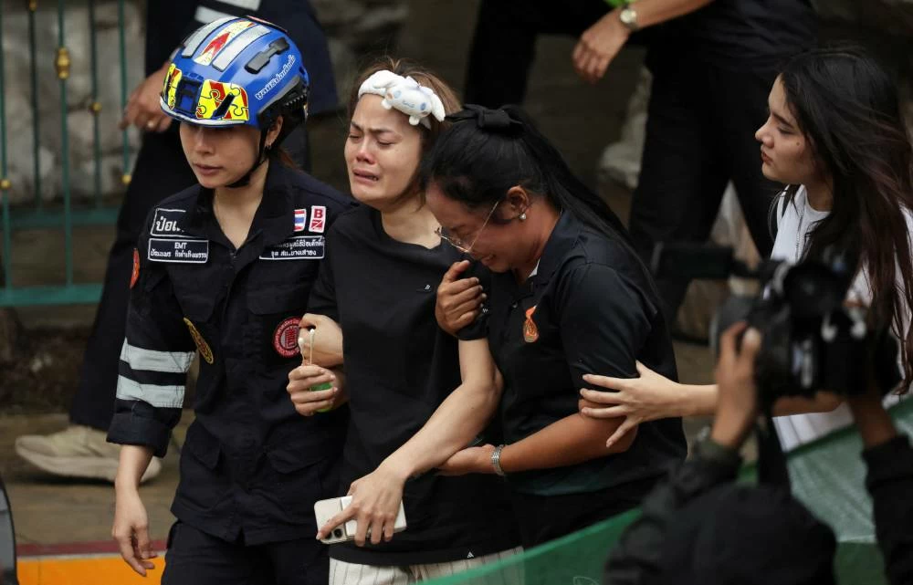 The wife of a teacher who was shot dead reacts at the Debsirin Nonthaburi School following the shooting incident, in Bang Kruai district in Nonthaburi province on the outskirts of Bangkok, Thailand, August 7, 2026. (Reuters)