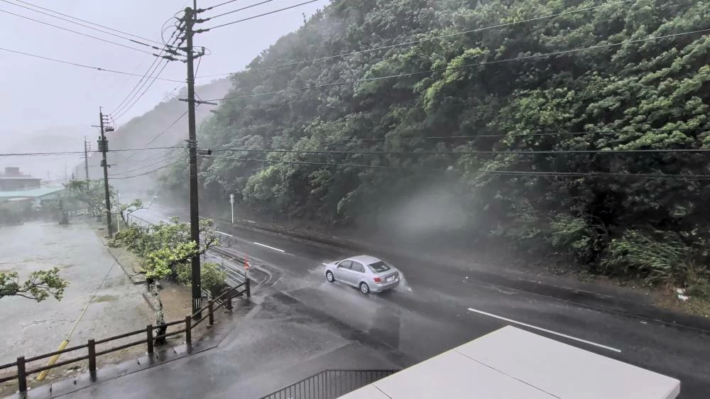 A car makes its way through strong winds and rain as Typhoon Dolphin approaches, in Nazeasahicho, Amami, Kagoshima, Japan, August 7, 2026, in this screengrab obtained from a social media video. (Credit: @darider5/X/via Reuters)