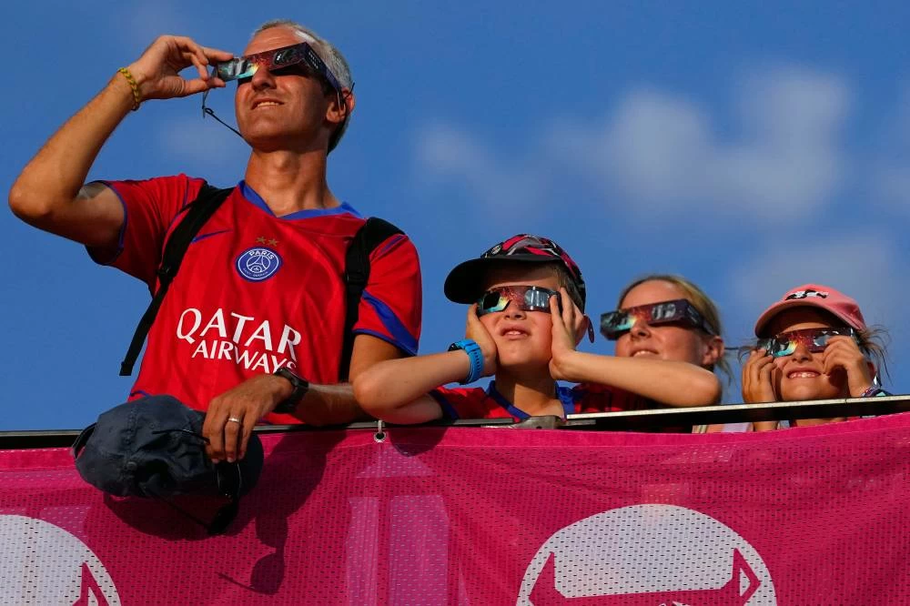 Spectators watch the solar eclipse at the European Athletics Championships in Birmingham, England, Wednesday, Aug. 12, 2026. Picture credit: AP