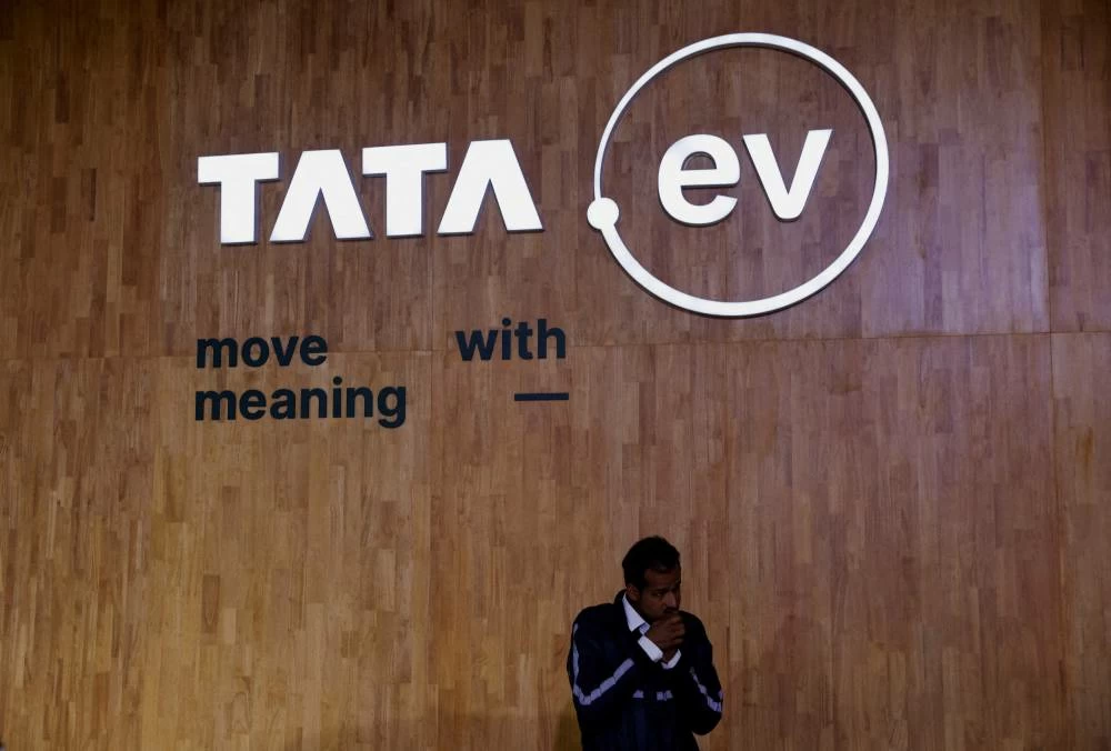 A man stands next to a sign of the brand of Tata Motors' passenger electric vehicles 'Tata.ev ' at Bharat Mobility Global Expo organised by India's commerce ministry at Pragati Maidan in New Delhi, India, February 1, 2024. (Reuters)
