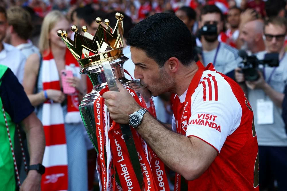 FILE PHOTO: Soccer Football - Premier League - Crystal Palace v Arsenal - Selhurst Park, London, Britain - May 24, 2026 Arsenal manager Mikel Arteta celebrates with the trophy after winning the Premier League. Picture credit: Reuters