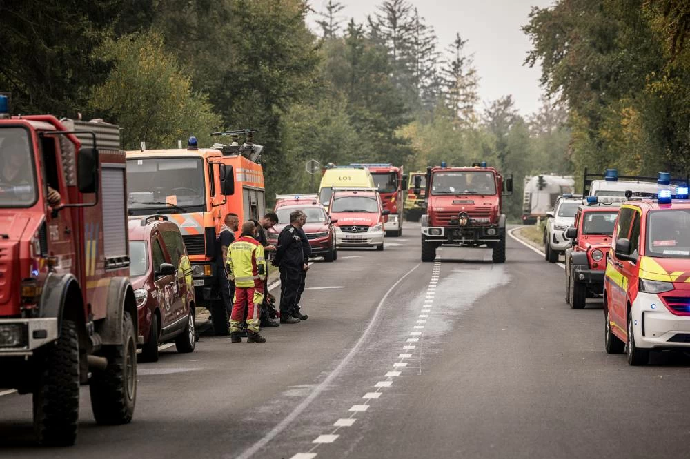 Fire department emergency vehicles stand on a street near an operations center to fight wildfires at the Hautes Fagnes near Eupen, in Belgium, Sunday, Aug. 16, 2026. AP