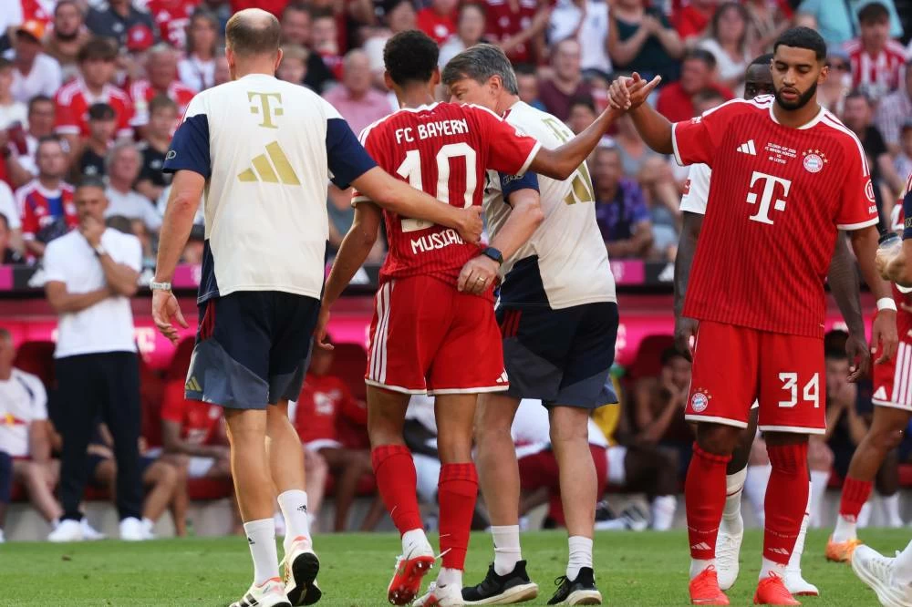 Munich's Jamal Musiala, center, leaves the pitch due to an injury during a pre-season soccer match between FC Bayern Munich and RB Leipzig in Munich, Germany, Saturday, Aug. 15, 2026. (AP)