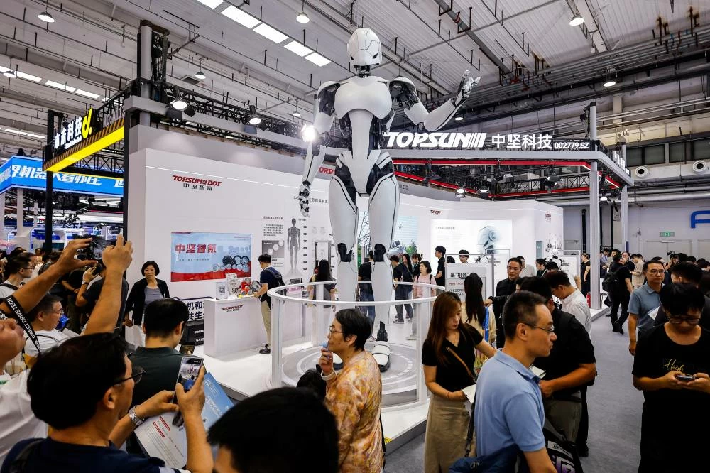 People take images of a giant humanoid robot installed at the Topsun Bot booth at the 2026 World Robot Conference, in Beijing, China, August 19, 2026. (Reuters)