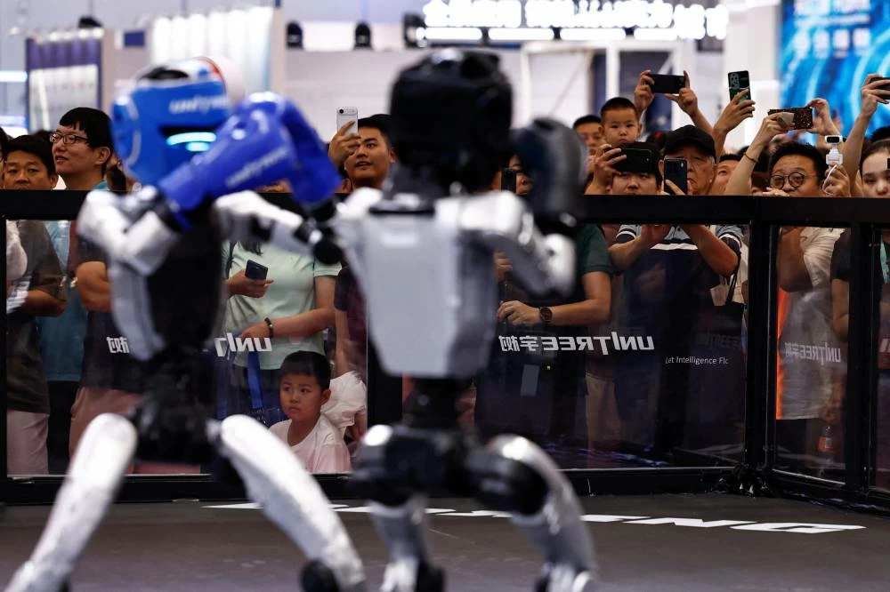 Visitors watch humanoid robots by Unitree Robotics demonstrating kickboxing during the 2026 World Robot Conference, in Beijing, China August 19, 2026. (Reuters)