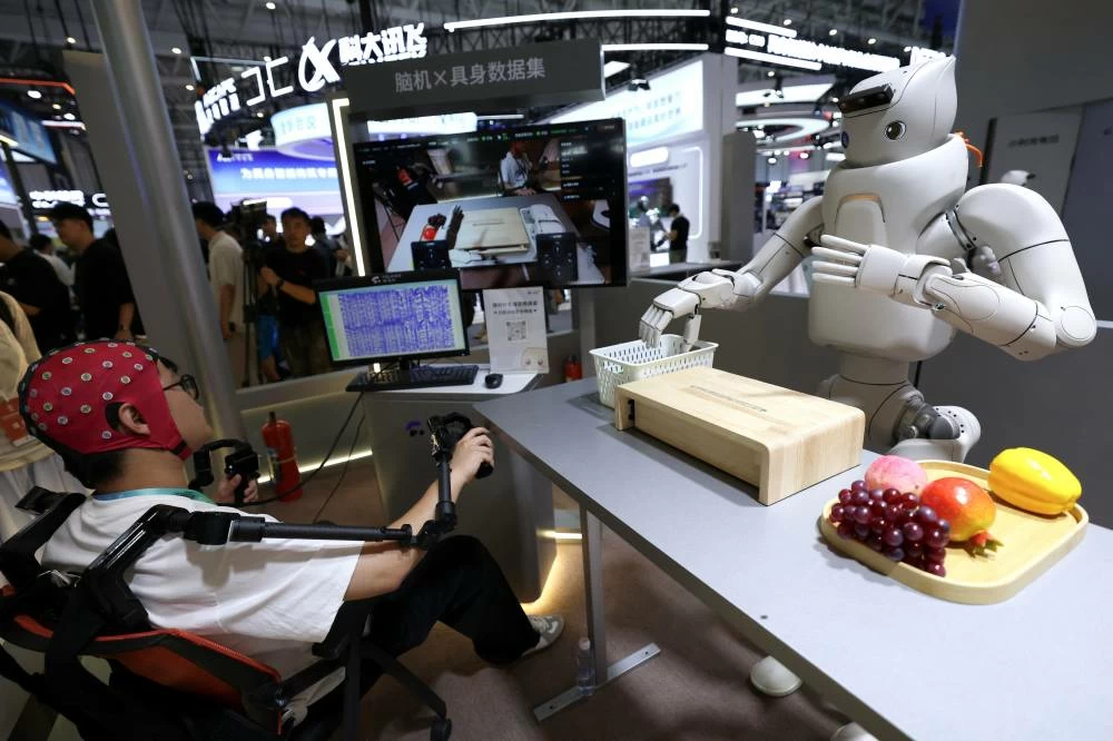 An engineer wears non-invasive brain-computer interface (BCI) head cap to pilot a humanoid robot, at the Fourier Intelligence booth during the 2026 World Robot Conference, in Beijing, China August 19, 2026. (Reuters)