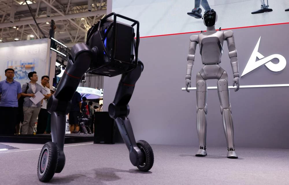 People watch a LimX Dynamics Luna humanoid robot standing next to another robot at the company's booth at the 2026 World Robot Conference, in Beijing, China, August 20, 2026. (Reuters)