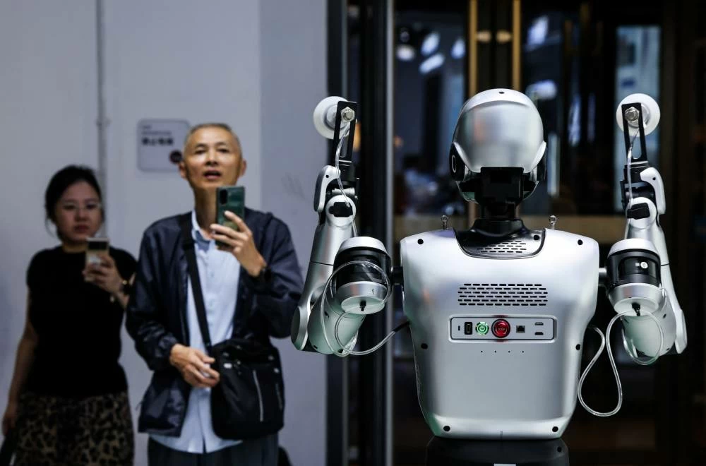 People take images of a humanoid robot at the Leju Robotics booth at the 2026 World Robot Conference, in Beijing, China, August 19, 2026. (Reuters)
