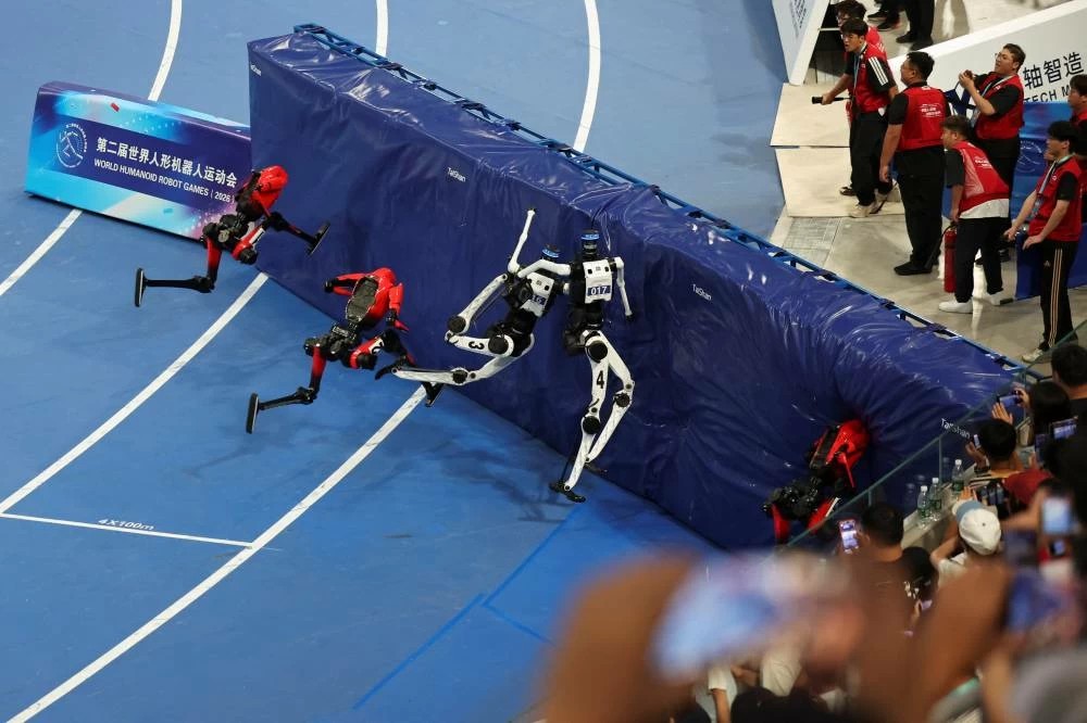Tiangong Ultra and Honor's Lightning humanoid robots clash onto a cushion after completing the 100m large-size group final race, during the second World Humanoid Robot Games at the National Speed Skating Oval in Beijing, China August 26, 2026. REUTERS