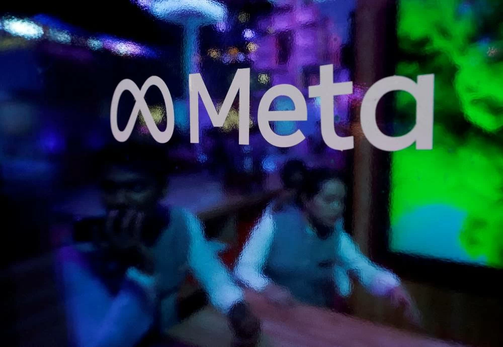 A photo showing people behind a logo of Meta Platforms. (File photo: Reuters)