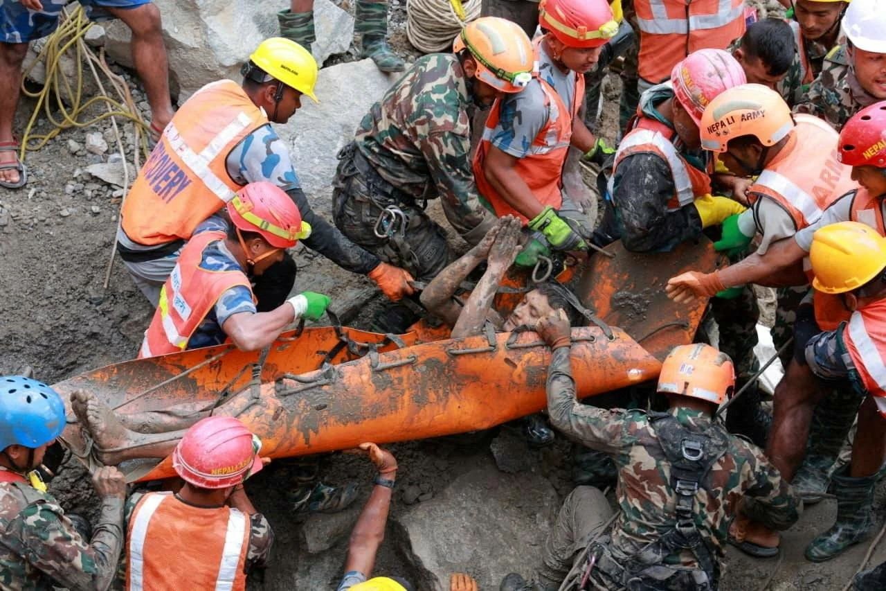 A survivor is carried by members of a search and rescue team after they rescued two people alive who had been trapped inside a tunnel at the Trishuli-3A Hydropower Project following devastating floods and mudslides that struck the Bhotekoshi River in Rasuwa, Nepal, September 4, 2026. Nepal Army/Handout via REUTERS.