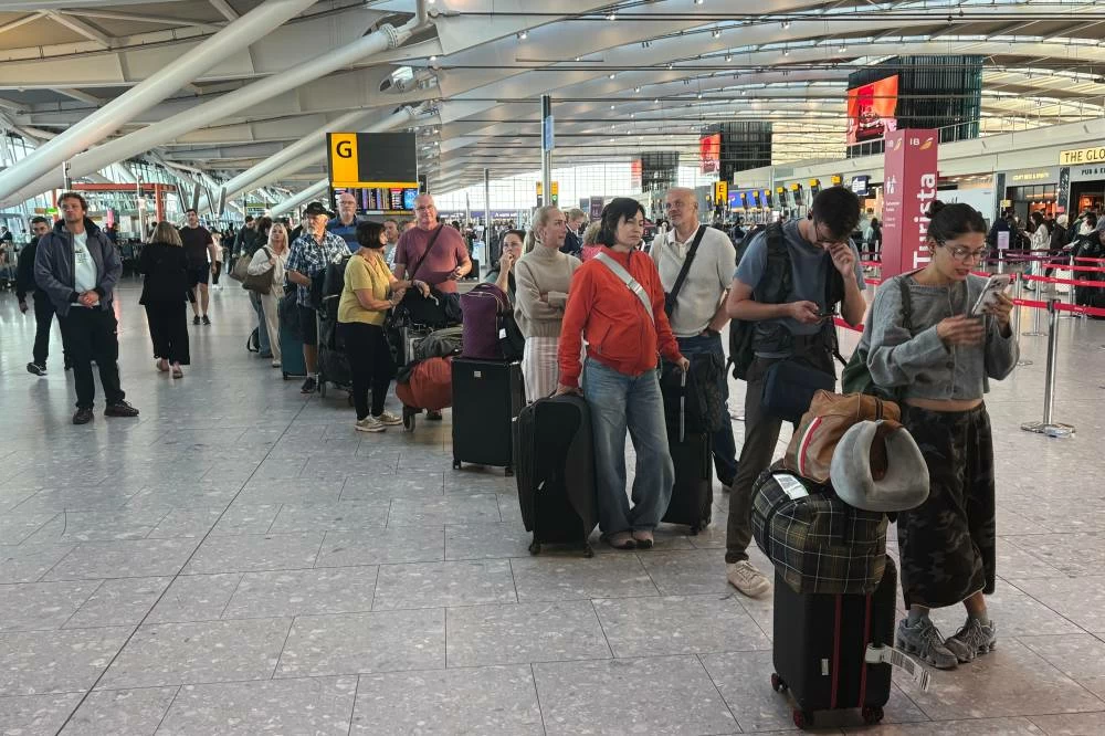 Passengers wait in line at Heathrow Airport in London, during an air traffic control problem that disrupted travel across Britain. AP