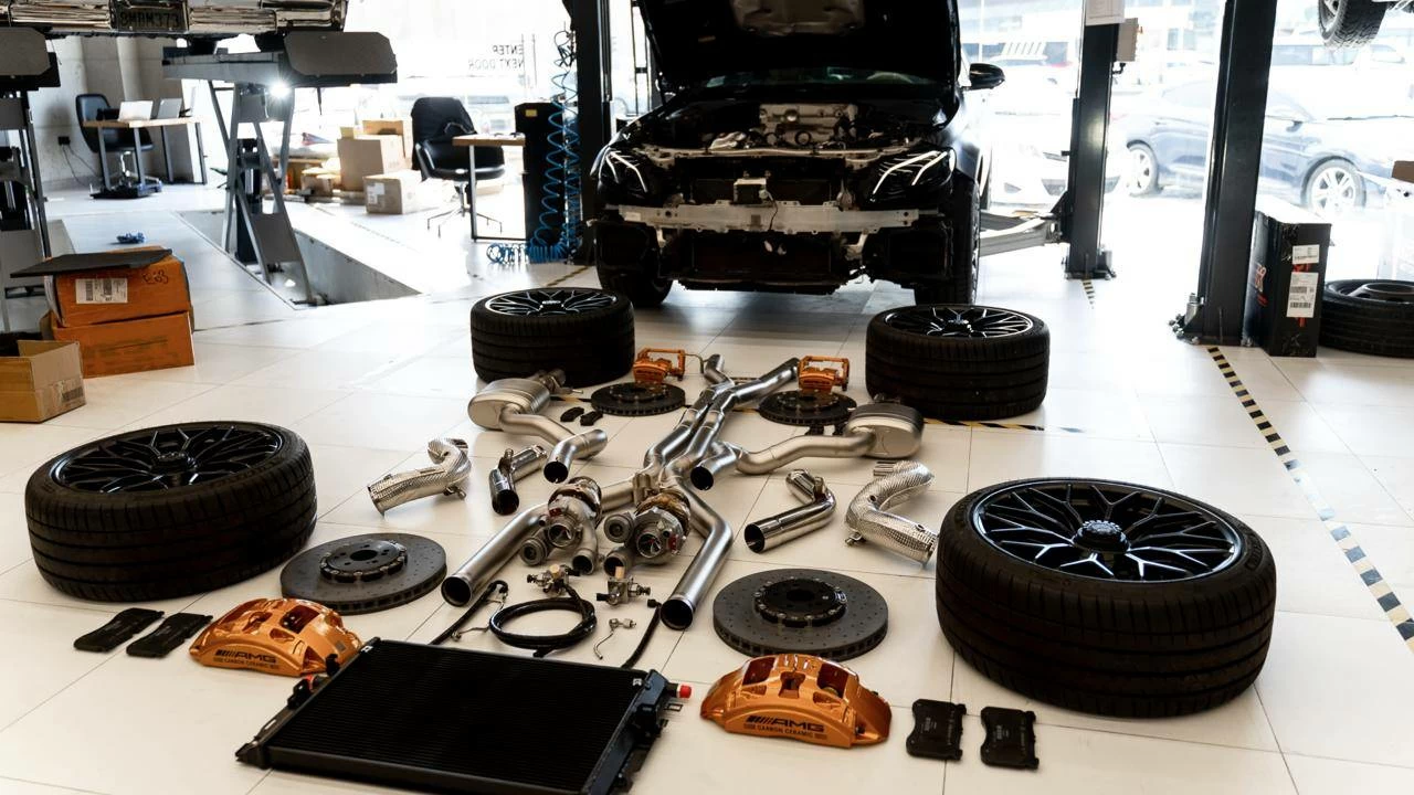 Components laid out at DEIZ Garage before a Mercedes-AMG E63 S build — turbochargers, exhaust, intercooler, carbon-ceramic brakes and wheels.