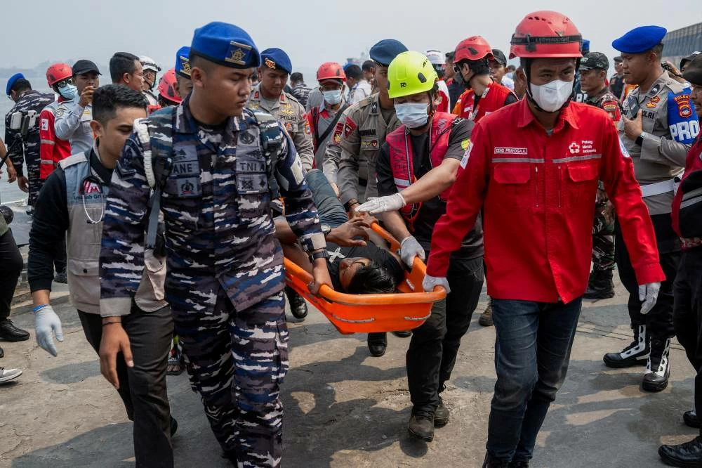 Rescuers using a stretcher carry a passenger of the Virgo Transport 8 ferry that capsized in the Java Sea while sailing from Surabaya in East Java to Banjarmasin in South Kalimantan, upon arrival at Trisakti port in Banjarmasin, South Kalimantan province, Indonesia, September 15, 2026. (Reuters)