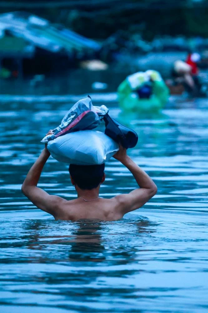A man wades through a flooded street during heavy rain in Bangkok, Thailand. REUTERS