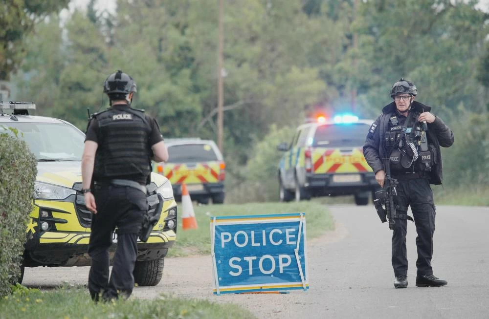 Police stand at a road block on the road to RAF Fairford after an incident, in Whelford, England, Sunday, Sept. 27, 2026 . AP