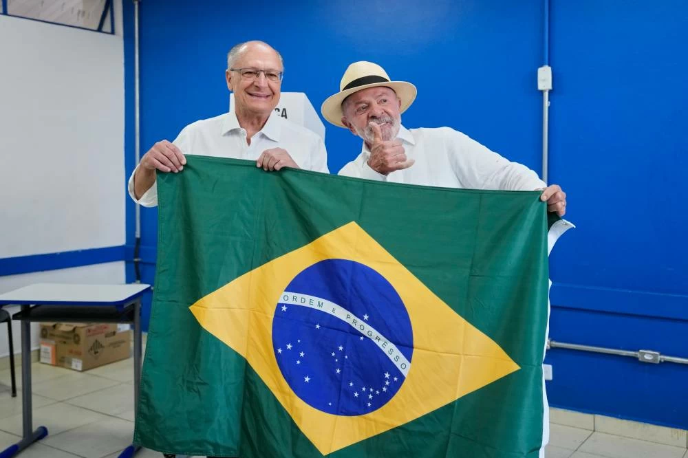 President Luiz Inacio Lula da Silva, who is running for reelection, and Vice President Geraldo Alckmin display a Brazilian flag before voting in Sao Bernardo do Campo, Brazil, Sunday, Oct. 4, 2026. AP