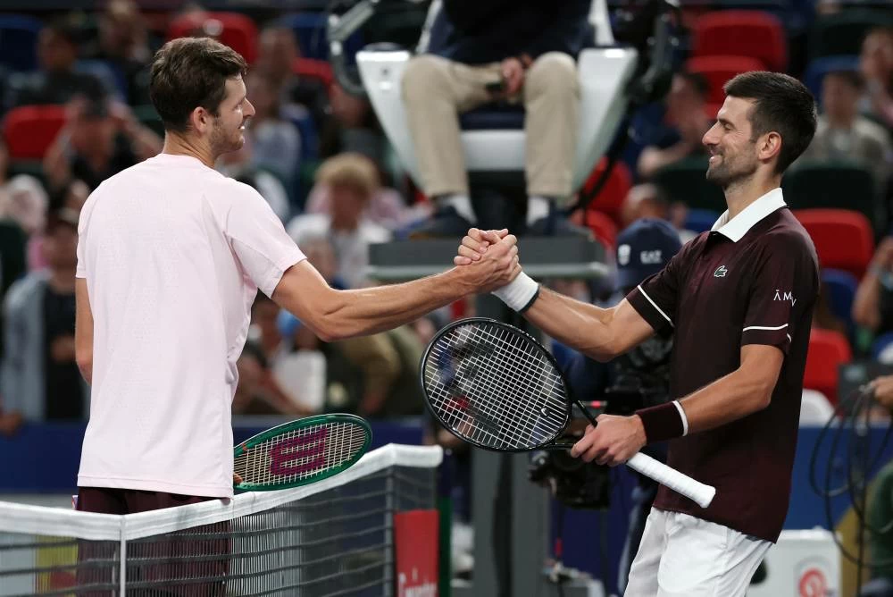 Poland's Hubert Hurkacz shakes hands with Serbia's Novak Djokovic after winning his round of 64 match. (Reuters)