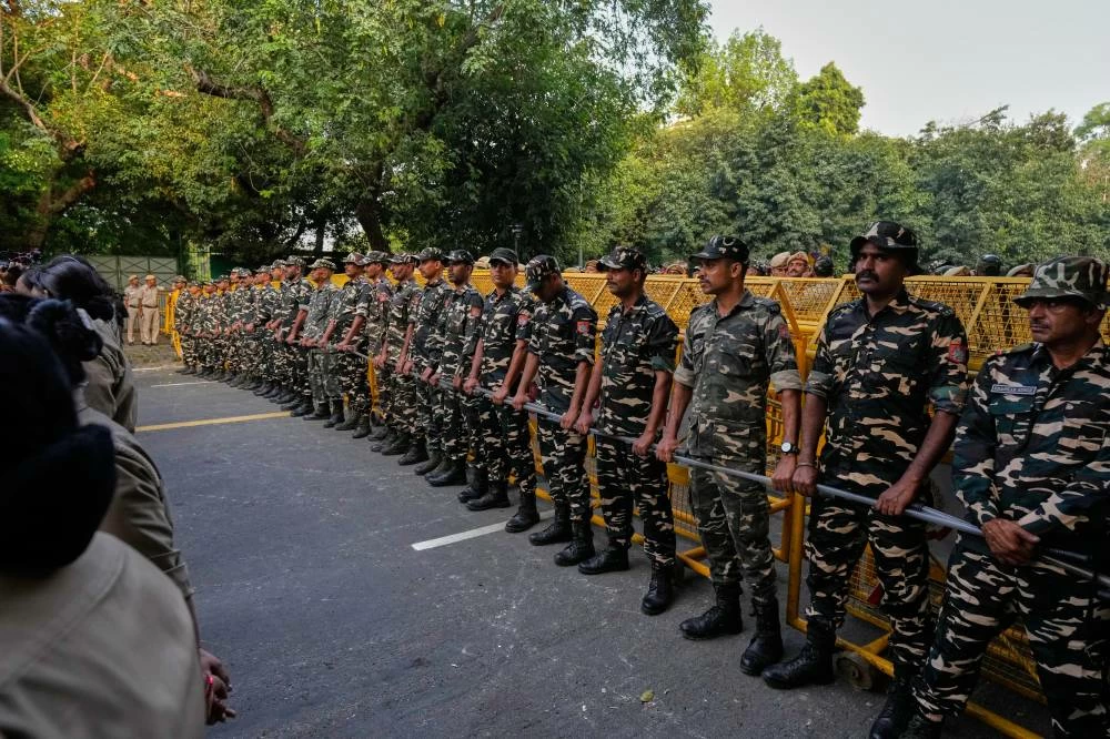 Security personnel stand guard at the barricades as they watch supporters of different political parties march toward the Supreme Court demanding the resignation of Chief Election Commissioner Gyanesh Kumar in New Delhi, India, Monday, Oct. 12, 2026. (AP)