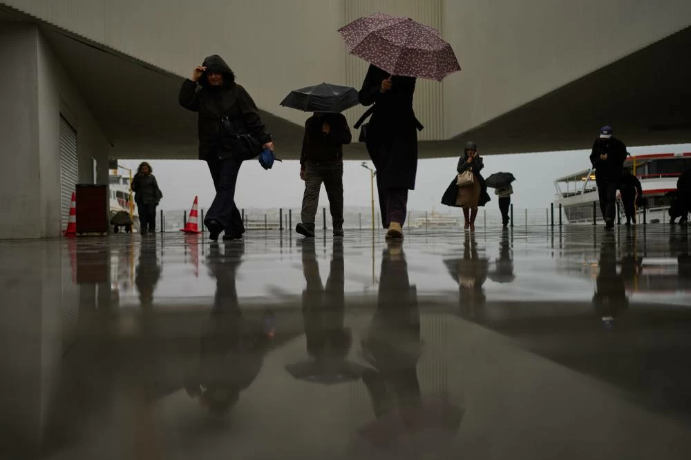 Commuters arrive to the Kabatas ferry terminal during a rain in Istanbul, Turkey, Thursday, Oct. 15, 2026. (AP)