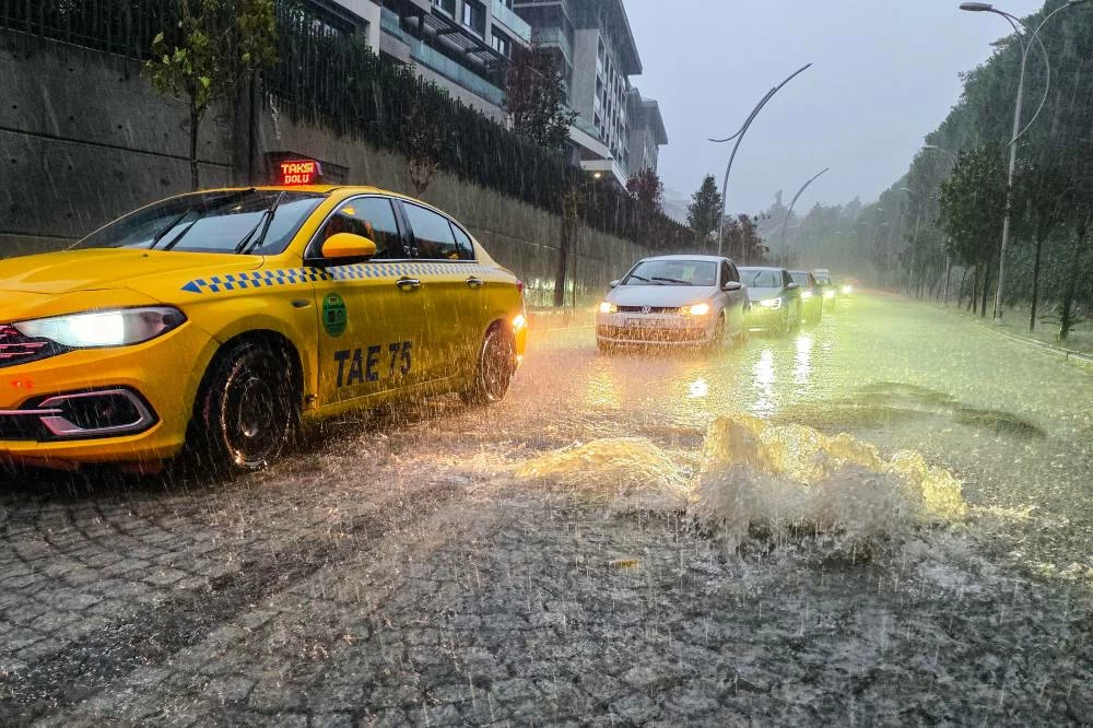 Vehicles drive along a partially flooded road during a heavy rain in Istanbul, Turkey, Wednesday, Oct. 14, 2026.  (AP)