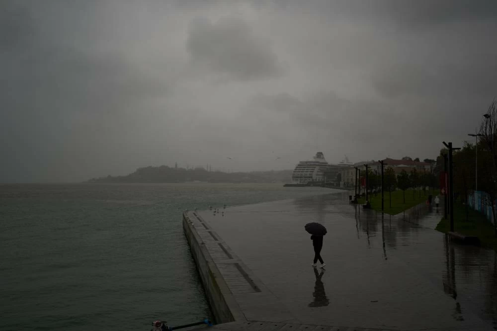 A man shelters under an umbrella against a shower rain at the Kabatas sea promenade in Istanbul, Turkey, Thursday, Oct. 15, 2026. (AP)