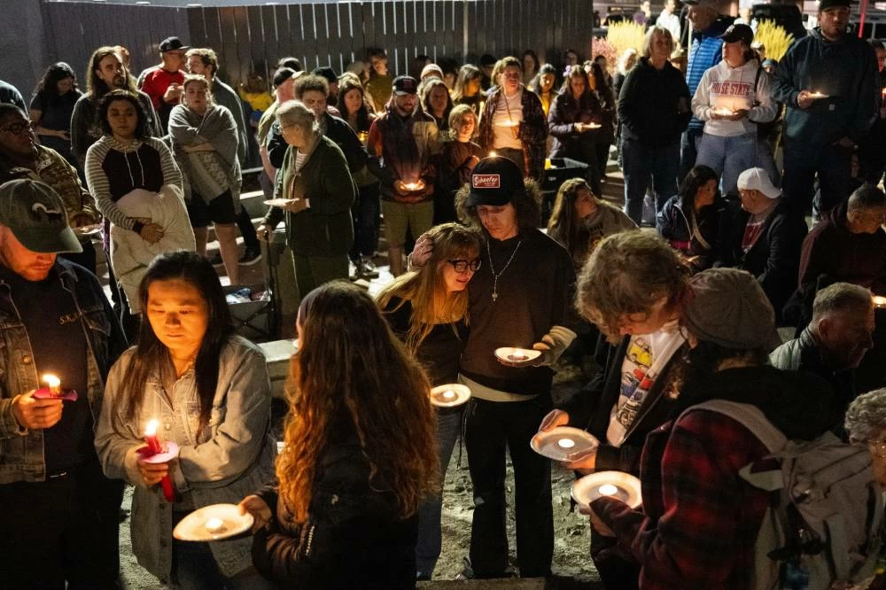 People hold candles and mourn during a candlelight vigil in downtown Bend, Ore., Friday, Oct. 16, 2026, a day after a deadly shooting. (AP)