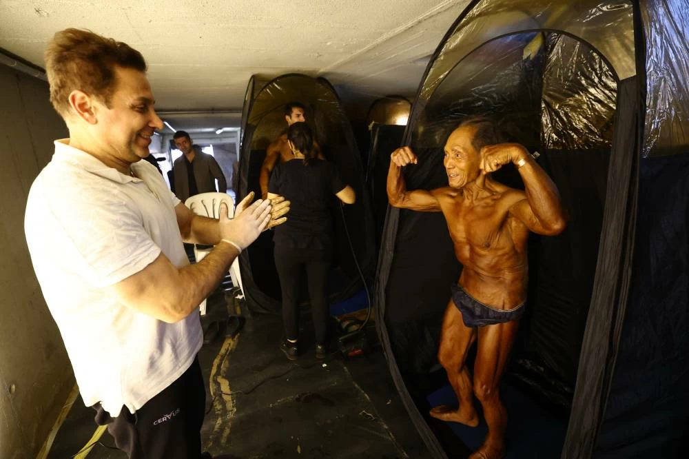 Toshisuke Kanazawa, 90, receives a spray tan ahead of the IFBB World Fitness Championships in Santa Susanna, Spain, on October 30, 2026. (Reuters)